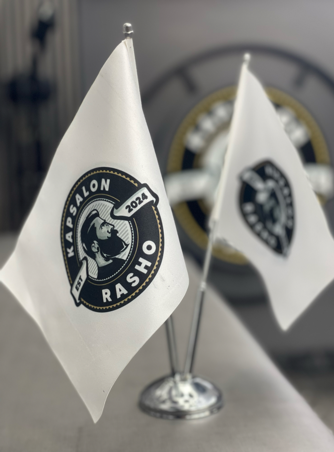 De zwart-witte vlaggetjes met het eigen ronde beeldmerk van Kapsalon Rasho
